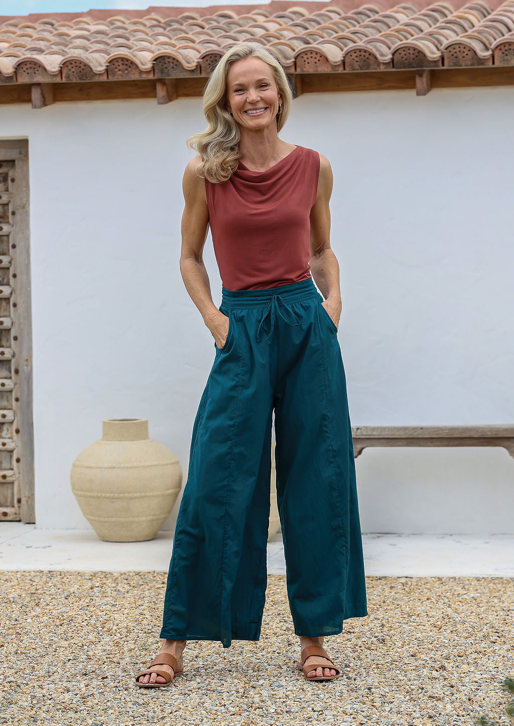 Woman wearing a terracotta sleeveless basic top and teal wide-leg cotton pants with drawstring, elasticated waist and pockets
