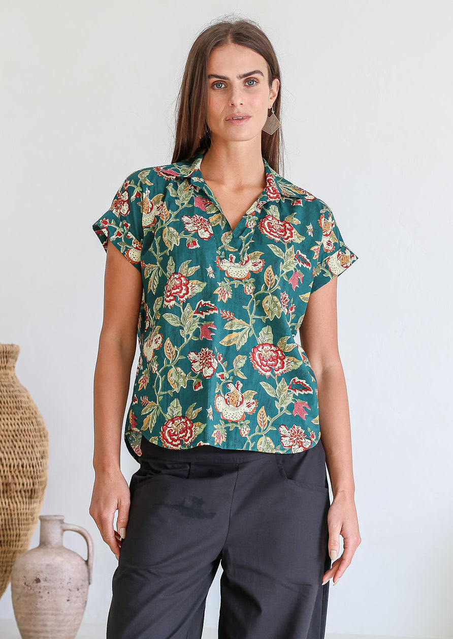 Woman poses in relaxed fit cotton short sleeve top with rolled cuffs sleeves, collar and V neckline.