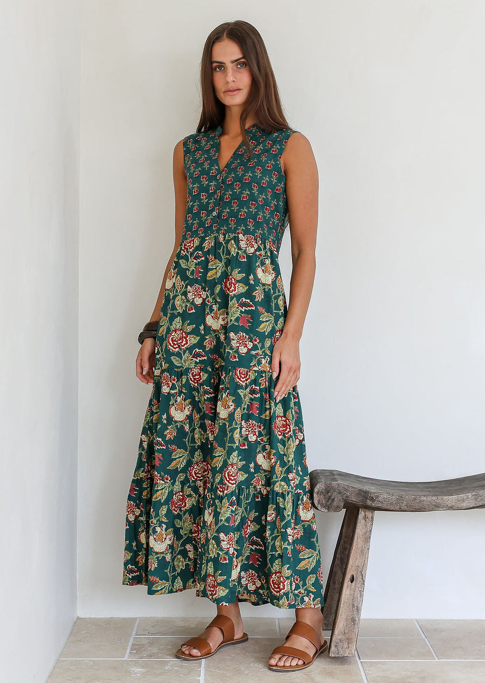 Model wearing a cotton three tiered maxi dress with 3/4 sleeves and buttoned bodice in combination of two green based floral prints.