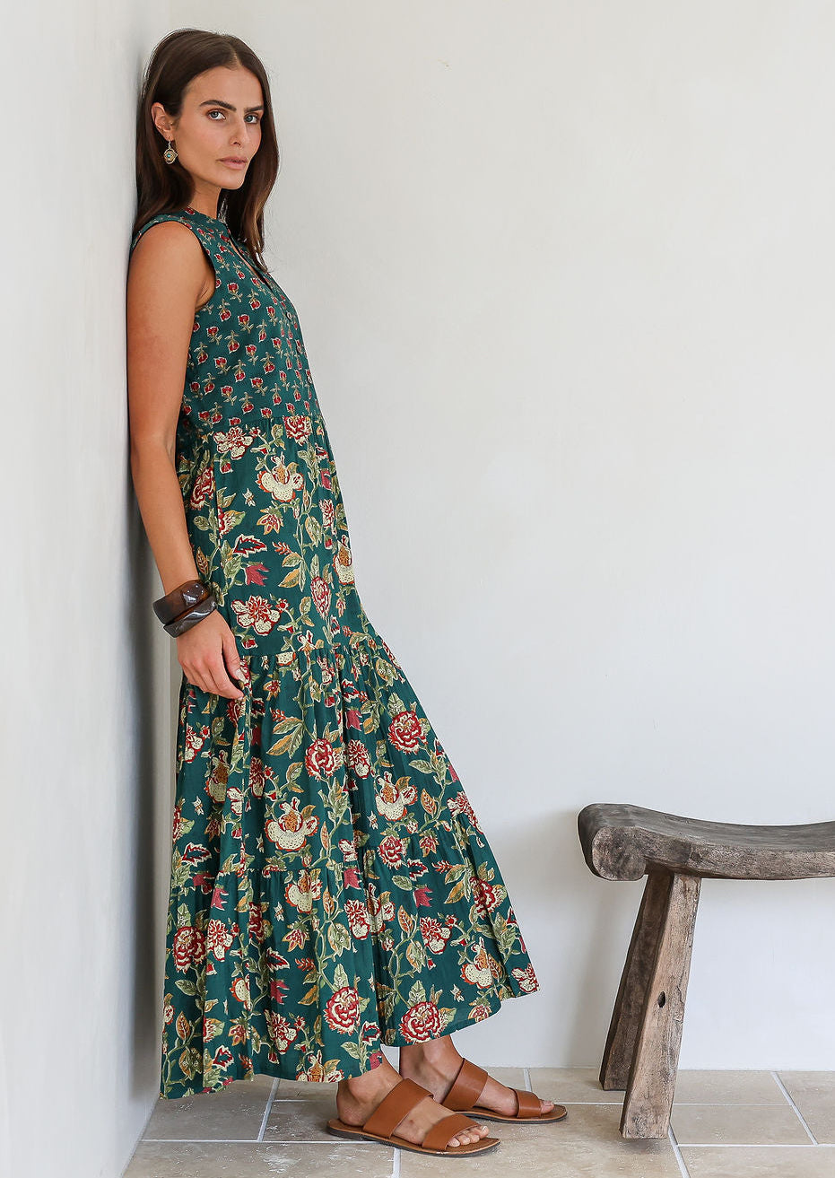 Model leans on wall wearing a beautiful floral printed cotton maxi dress with buttoned bodice, 3/4 sleeves and V neckline.