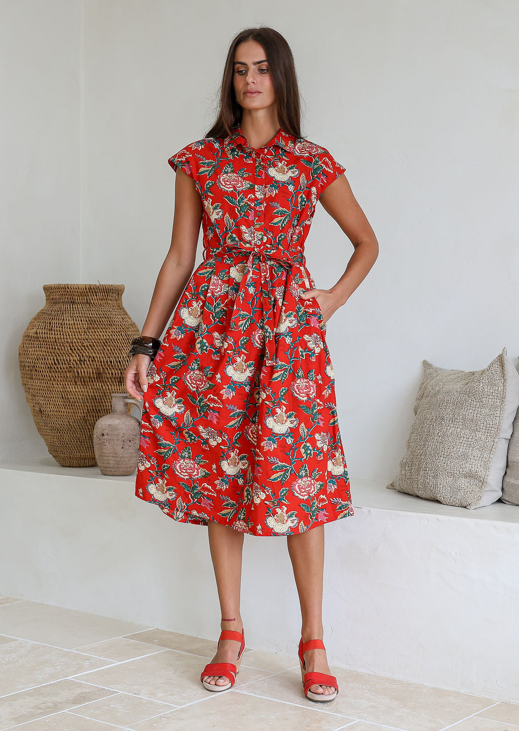 Model posing in a red floral print shirt style 100% cotton dress with cap sleeves and detachable waist tie