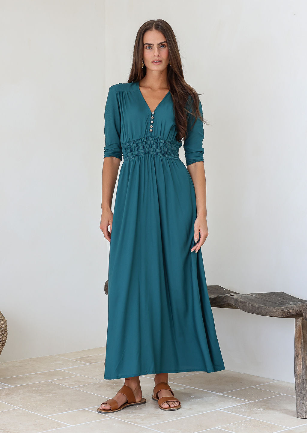 Woman wearing a sophisticated teal rayon maxi dress with a v-neckline and elbow length sleeves
