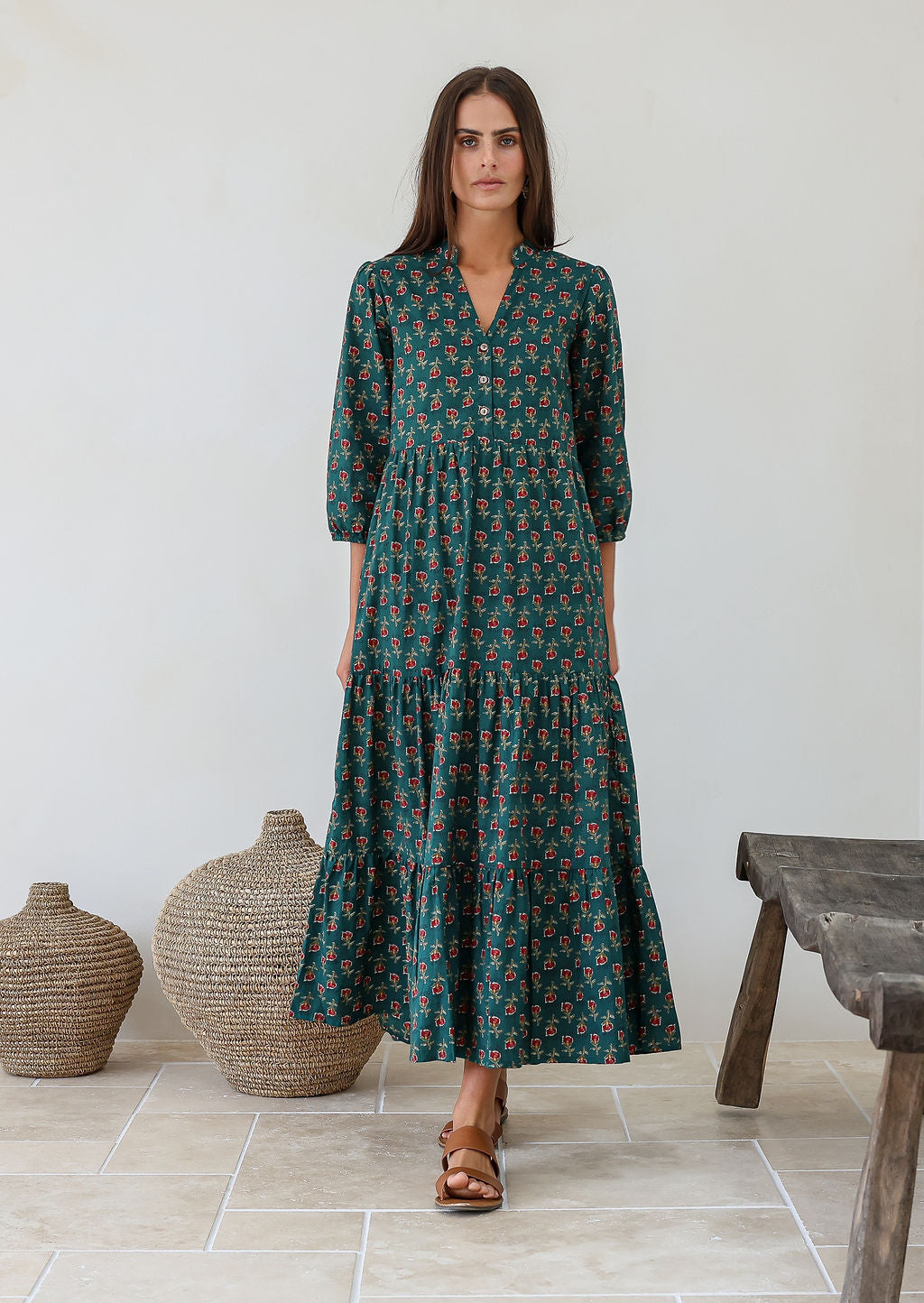 Model wears green based floral maxi dress with buttoned bodice, mandarin collar, 3/4 sleeves and pockets