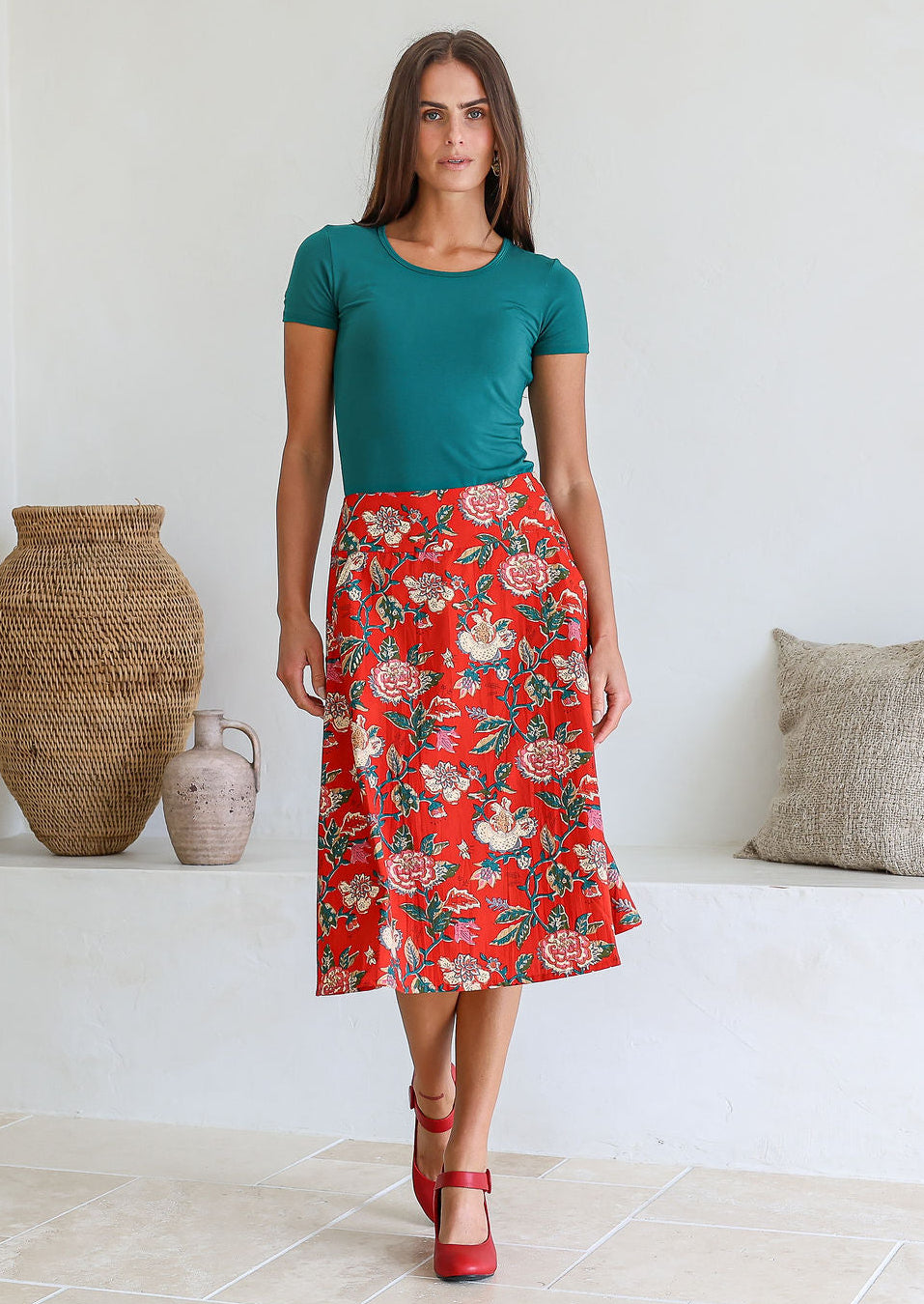Model wearing 100% cotton knee length A-line skirt with side zipper and pockets in red based floral print