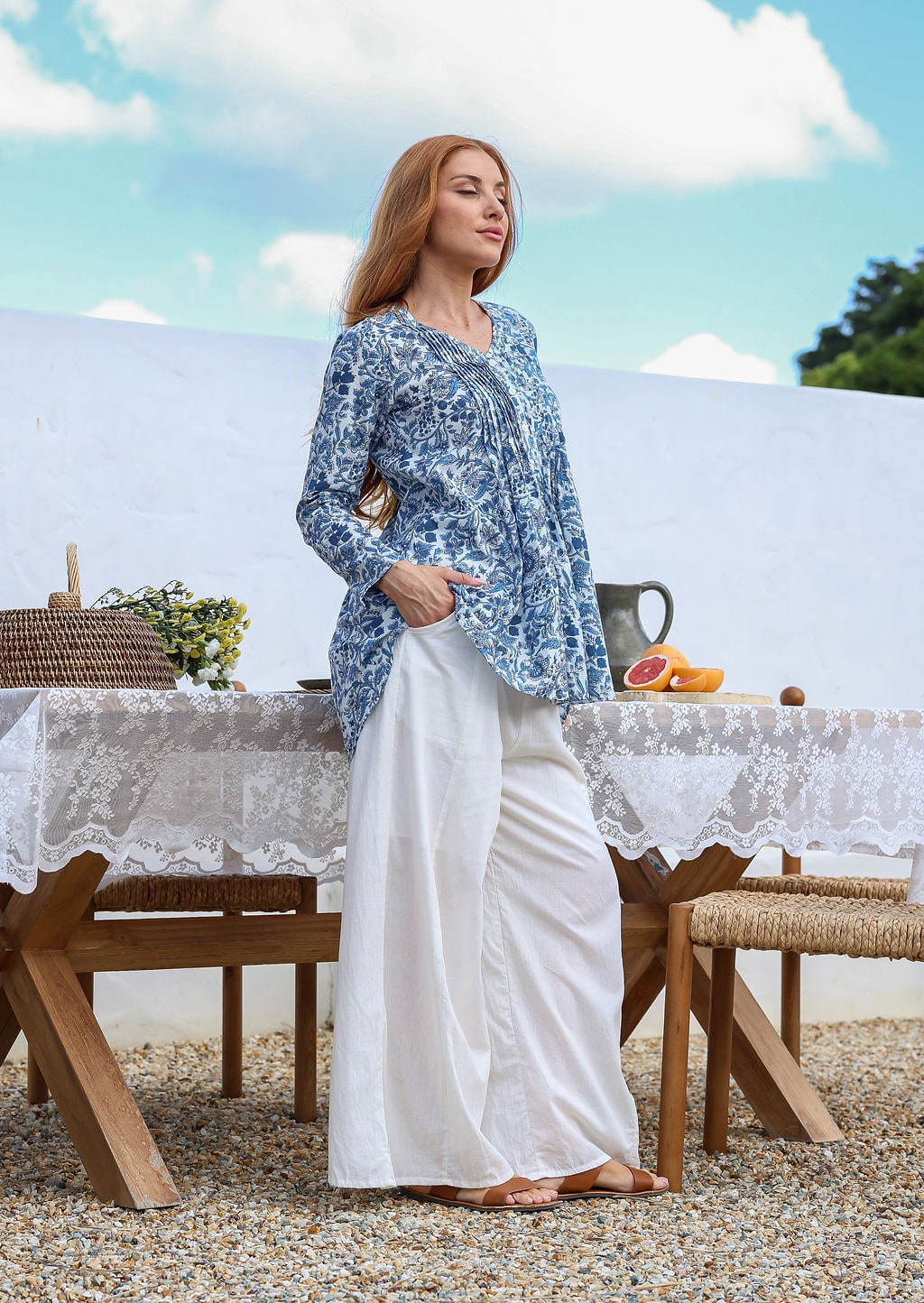 Woman wearing a 100% cotton white based blue floral print top with white wide-leg pants.