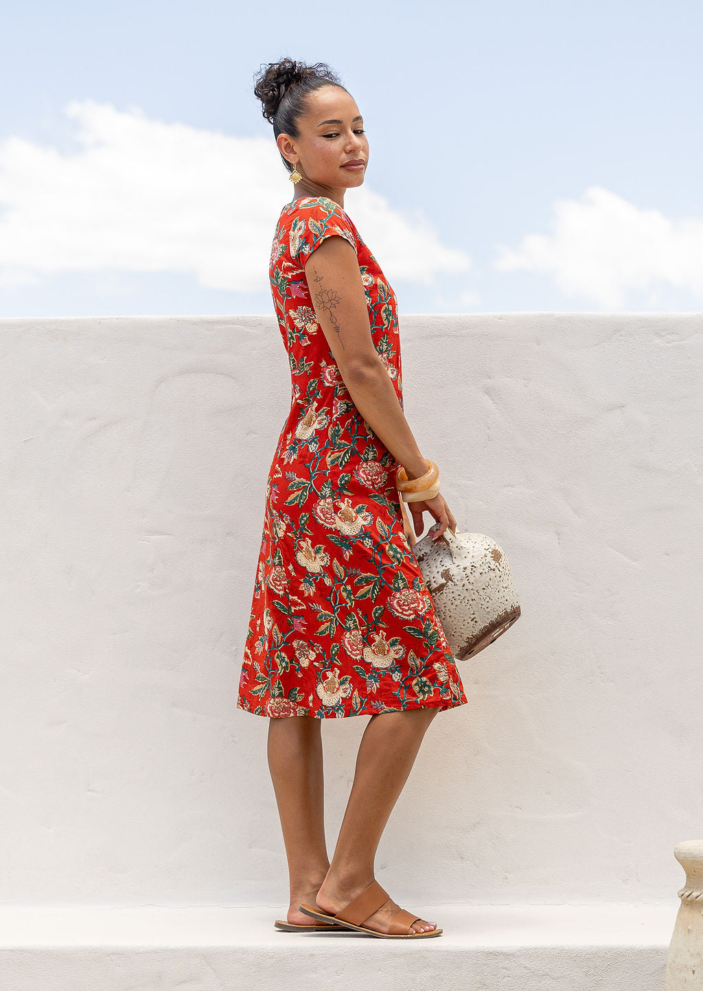 Woman in bright red floral cotton dress