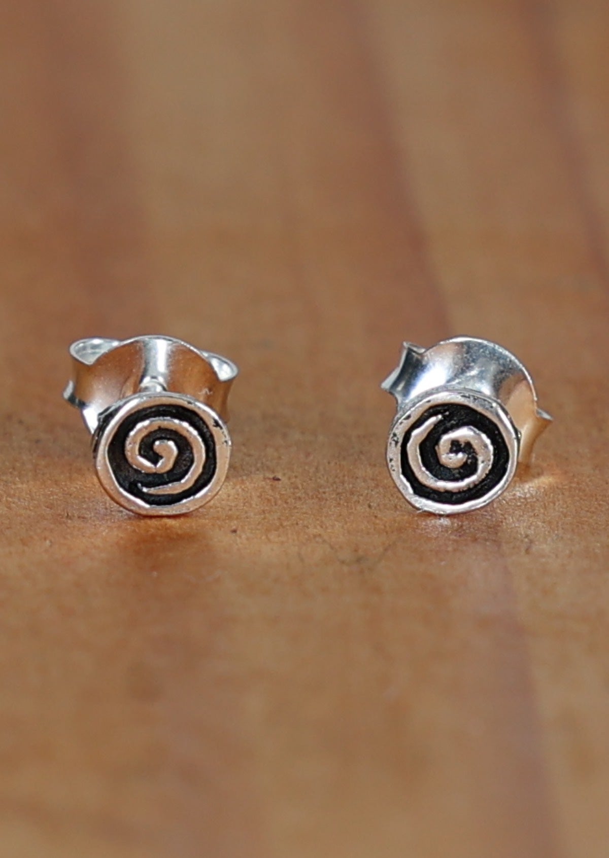 Swirls Silver Stud earrings featuring a 4mm silver disk with a swirl imprinted on the front