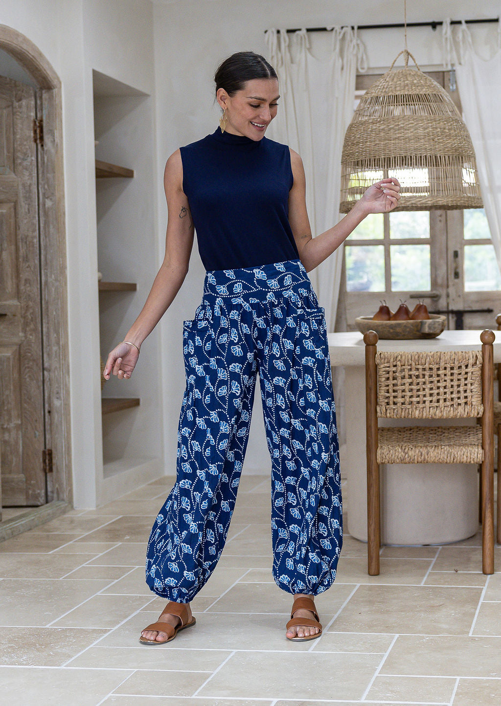 Woman wearing a blue basic top and navy blue based floral pants with wide elastic waist