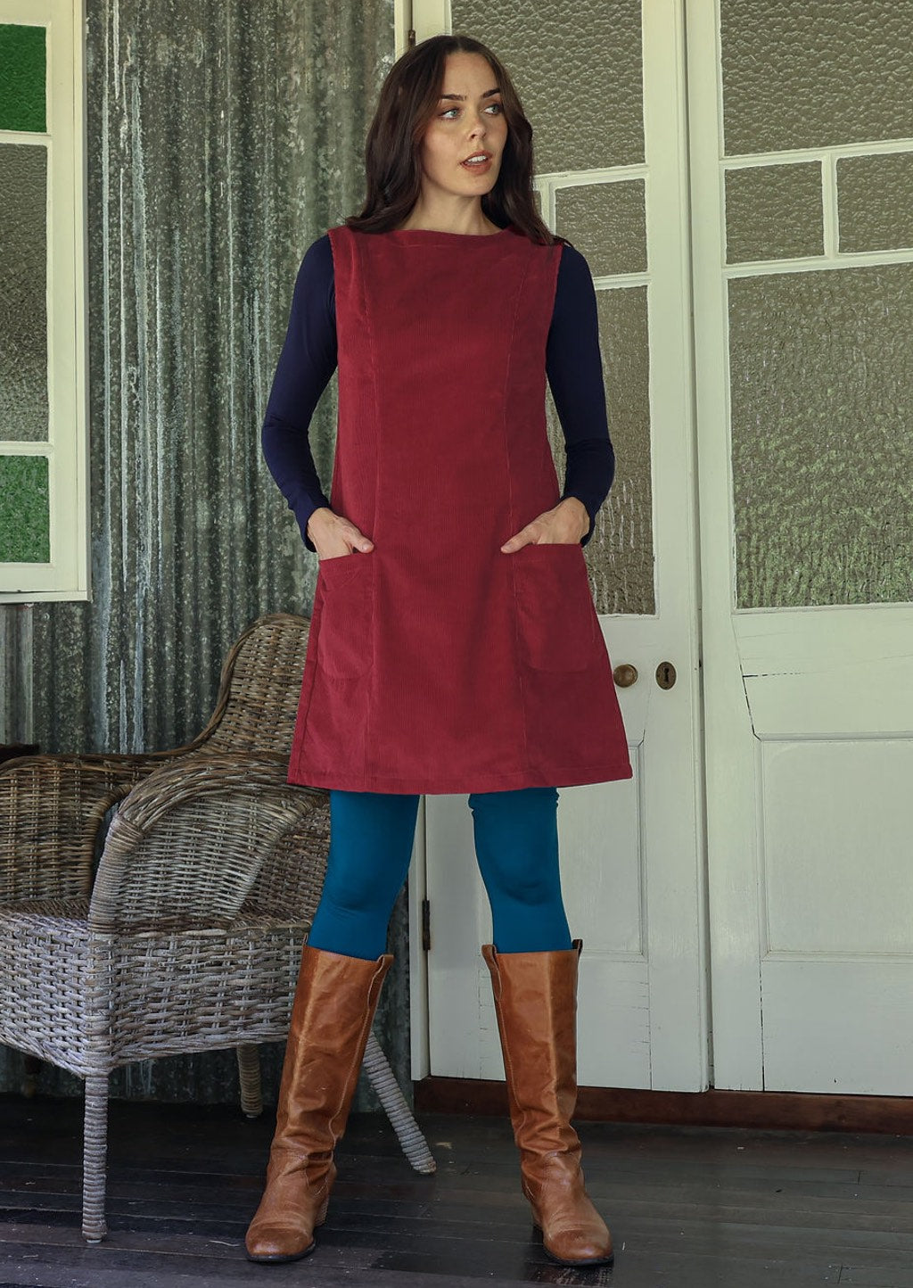 Woman wearing cotton corduroy tunic in cabernet with boat neck with hand in pocket