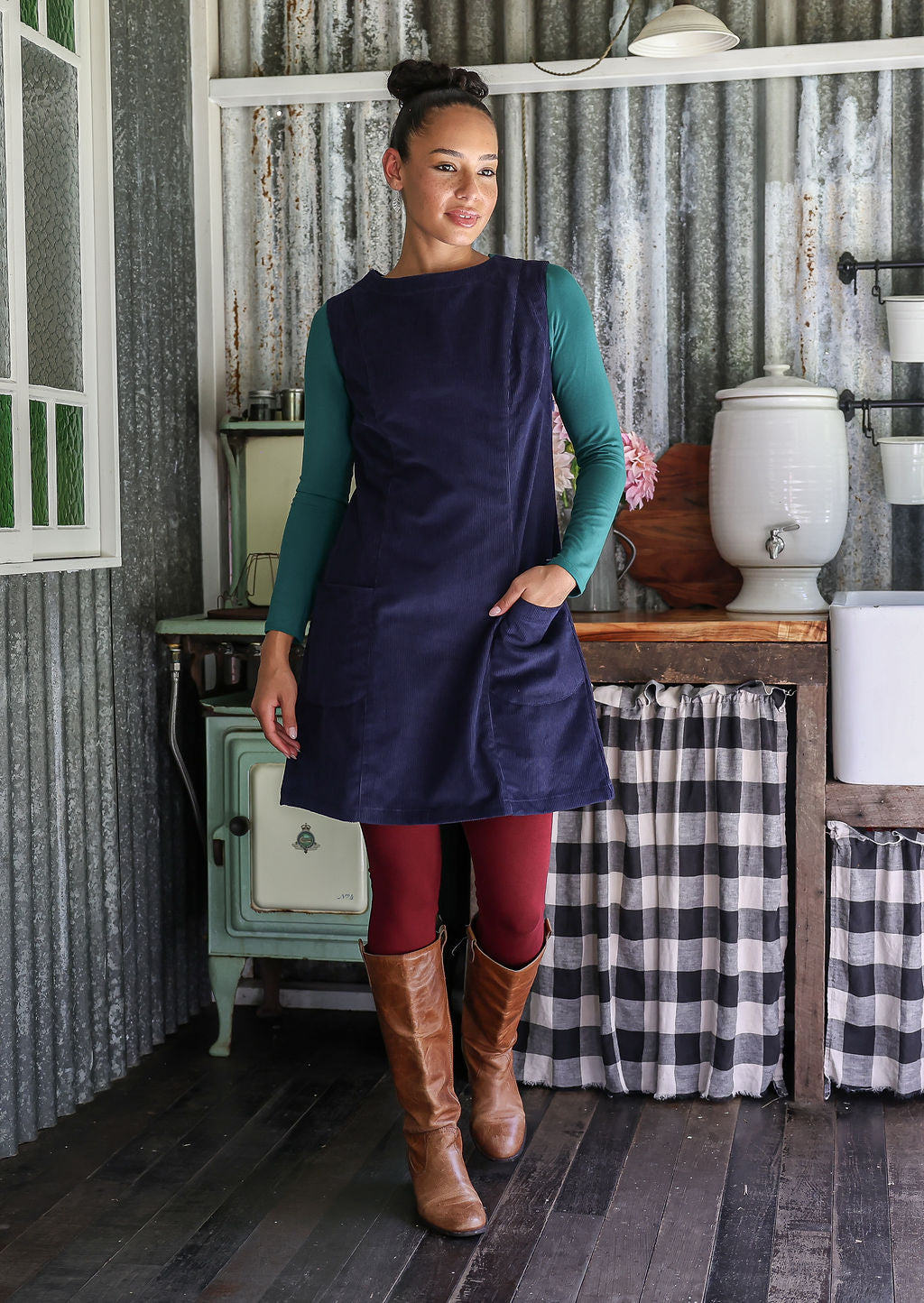 Woman wearing cotton corduroy tunic in navy blue with boat neck with hand in pocket