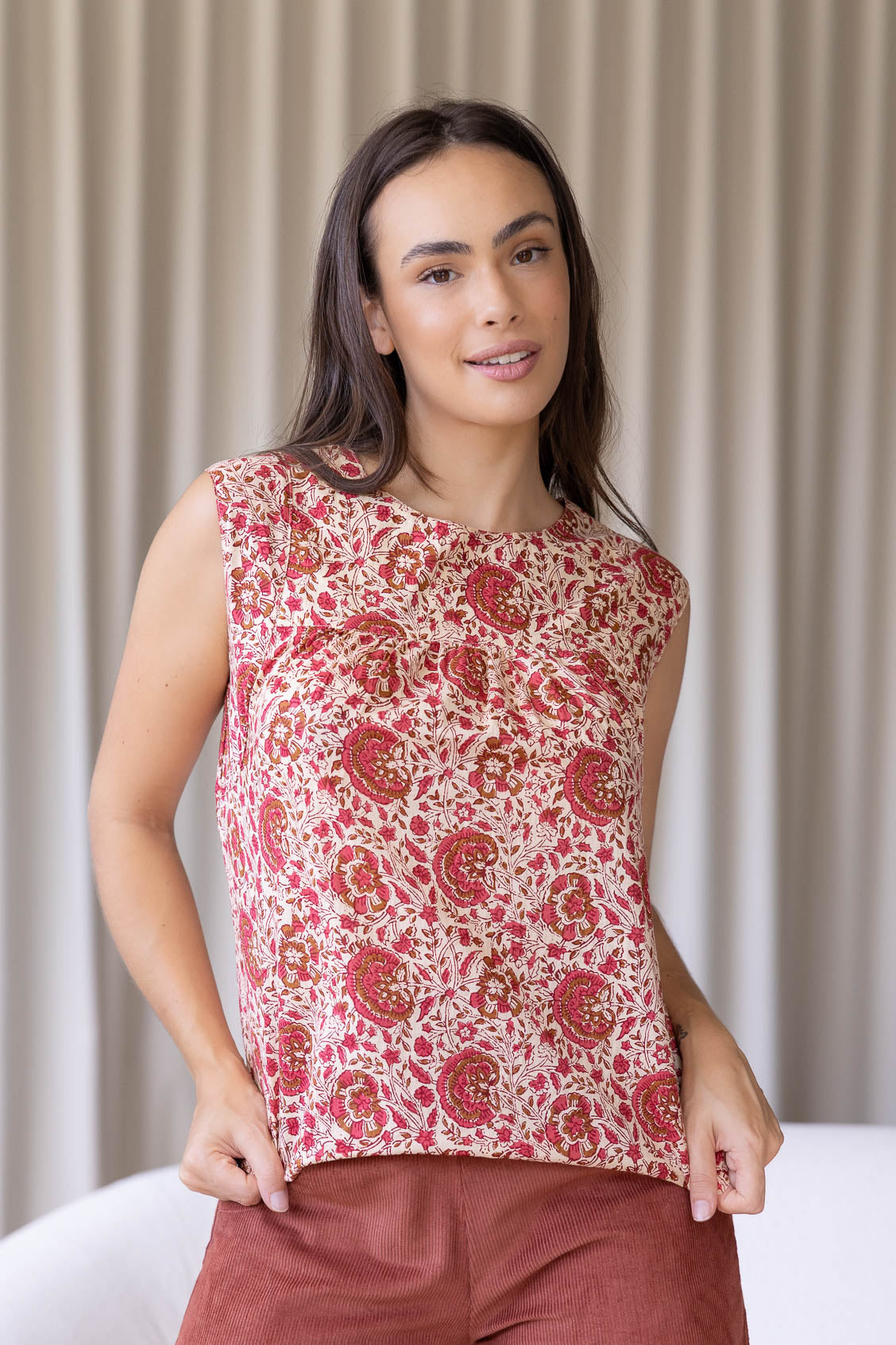 Woman wears 100% cotton gentle cream based floral print cotton sleeveless top with small gathers across the bust