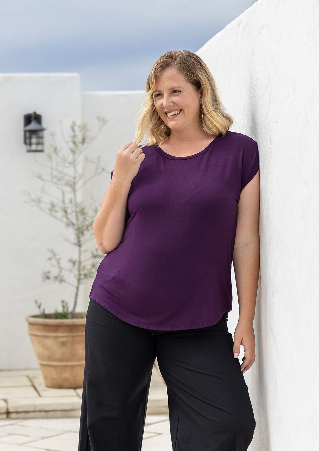 Woman poses in a soft flattering fit purple rayon jersey t-shirt.