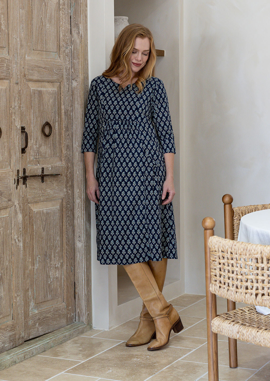 Woman wearing a relaxed fit below knee length cotton dress with 3/4 sleeves, pockets and round neckline.