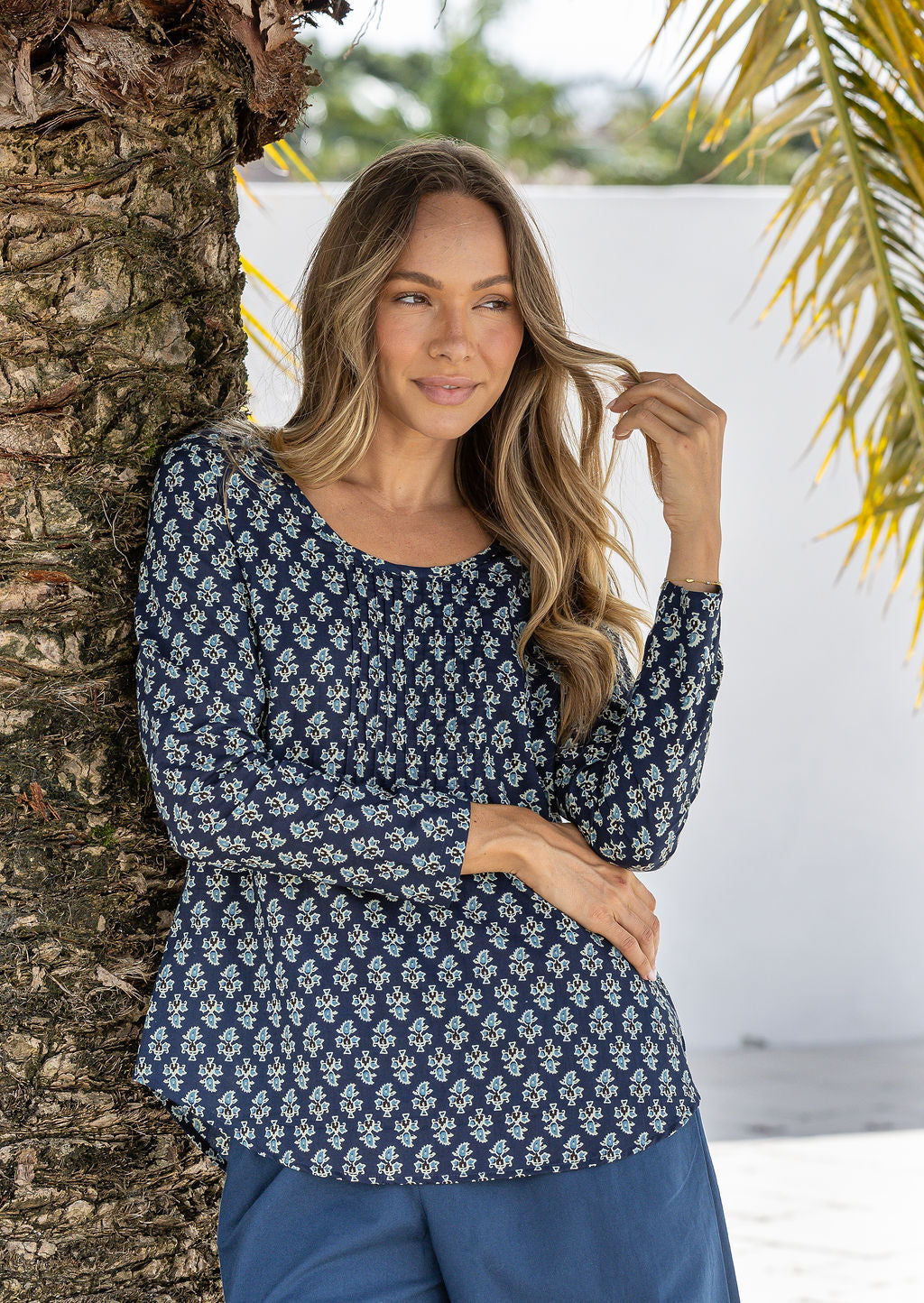Model wearing a flattering long sleeve top with beautiful navy blue based florals.