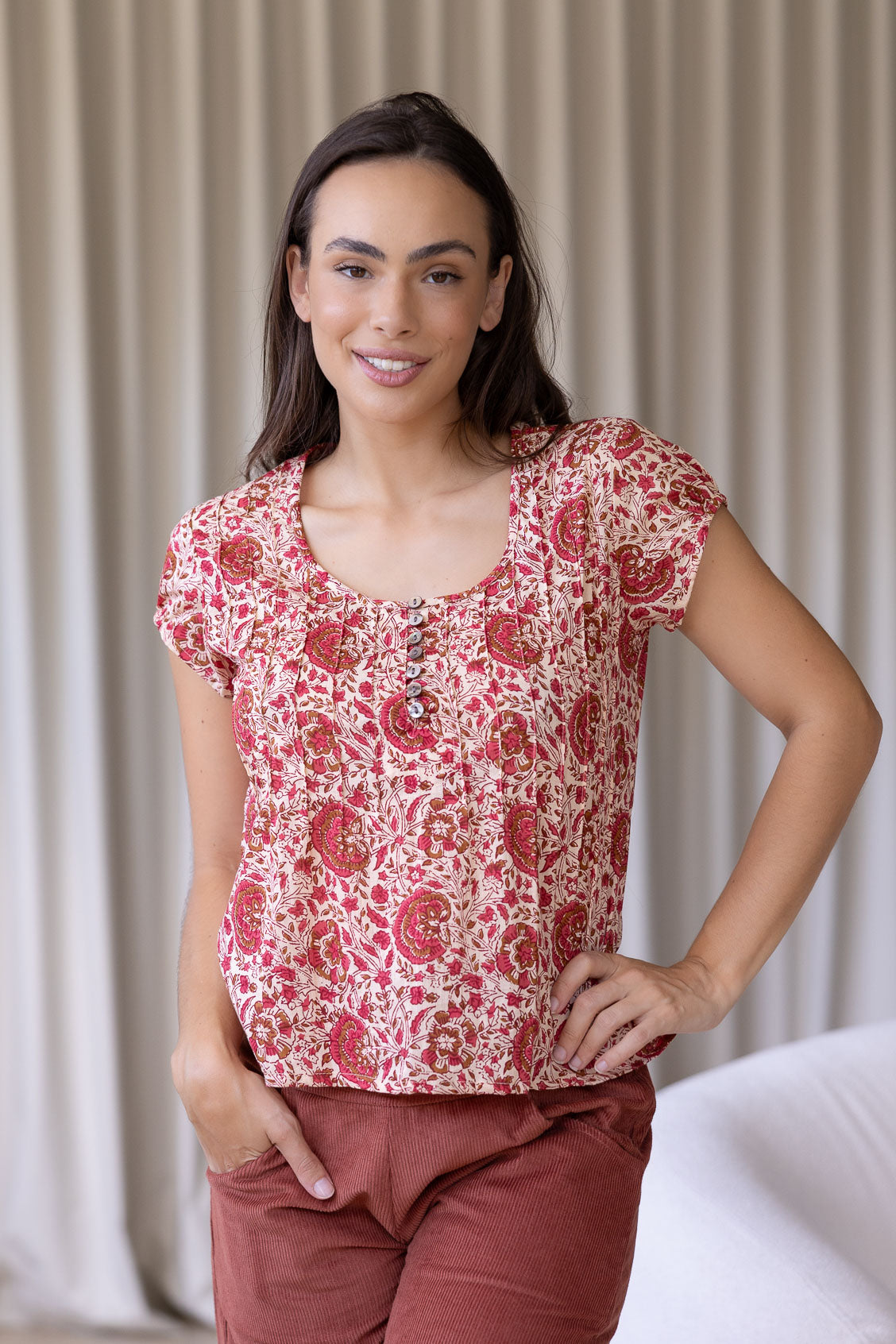 Woman wearing a 100% cotton floral top and plain pants.