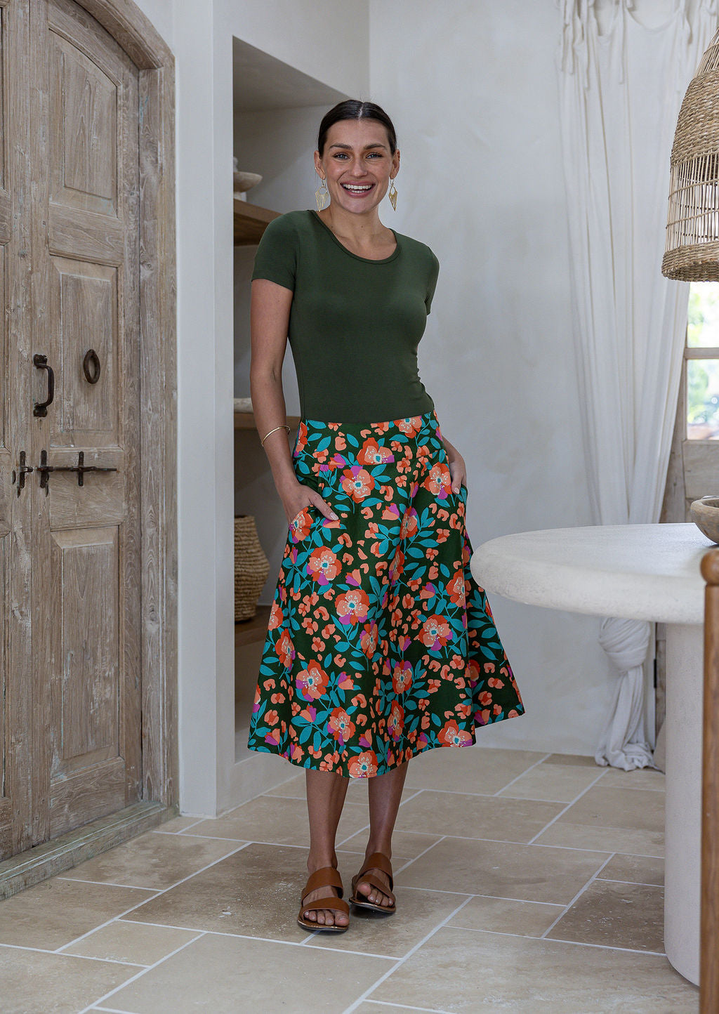Woman wearing a basic top and olive green based floral a-line cotton skirt with side zipper