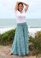 Model pairs boho style ultra wide leg pants with a basic short sleeved white top