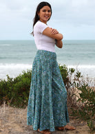 Model standing sideways wearing a 100% rayon floral printed, super wide leg pants.