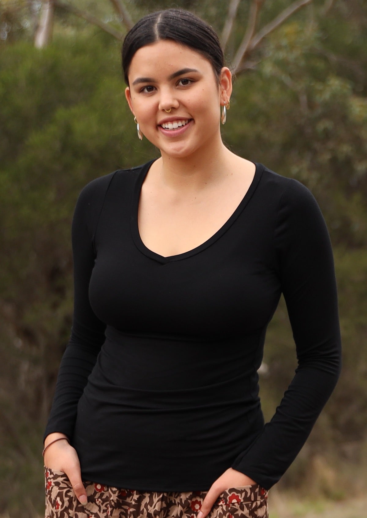 Woman wearing black long sleeve stretch v-neck soft rayon top.