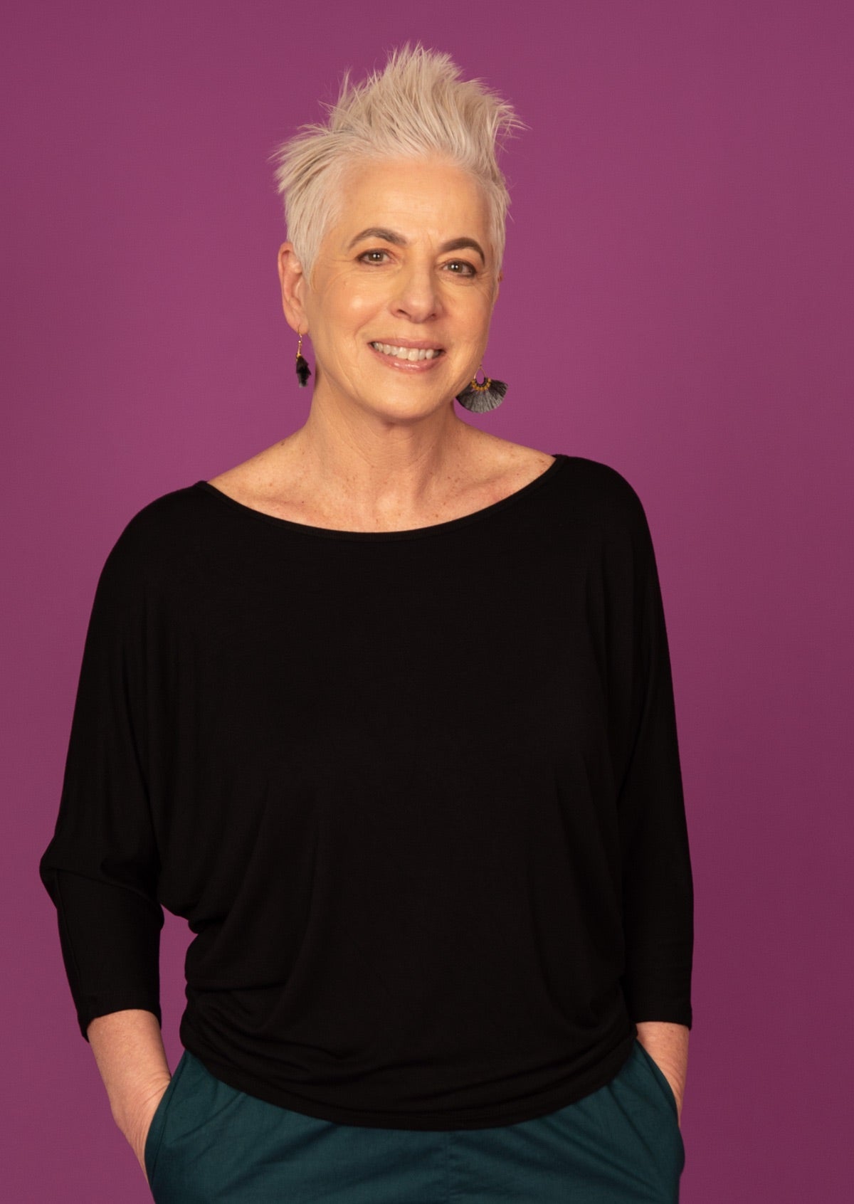 Woman wearing a 3/4 sleeve rayon batwing round neckline black top.