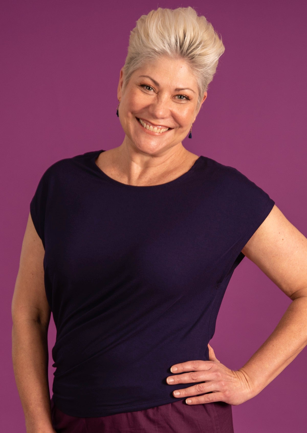 Woman with blonde short hair wearing navy blue top