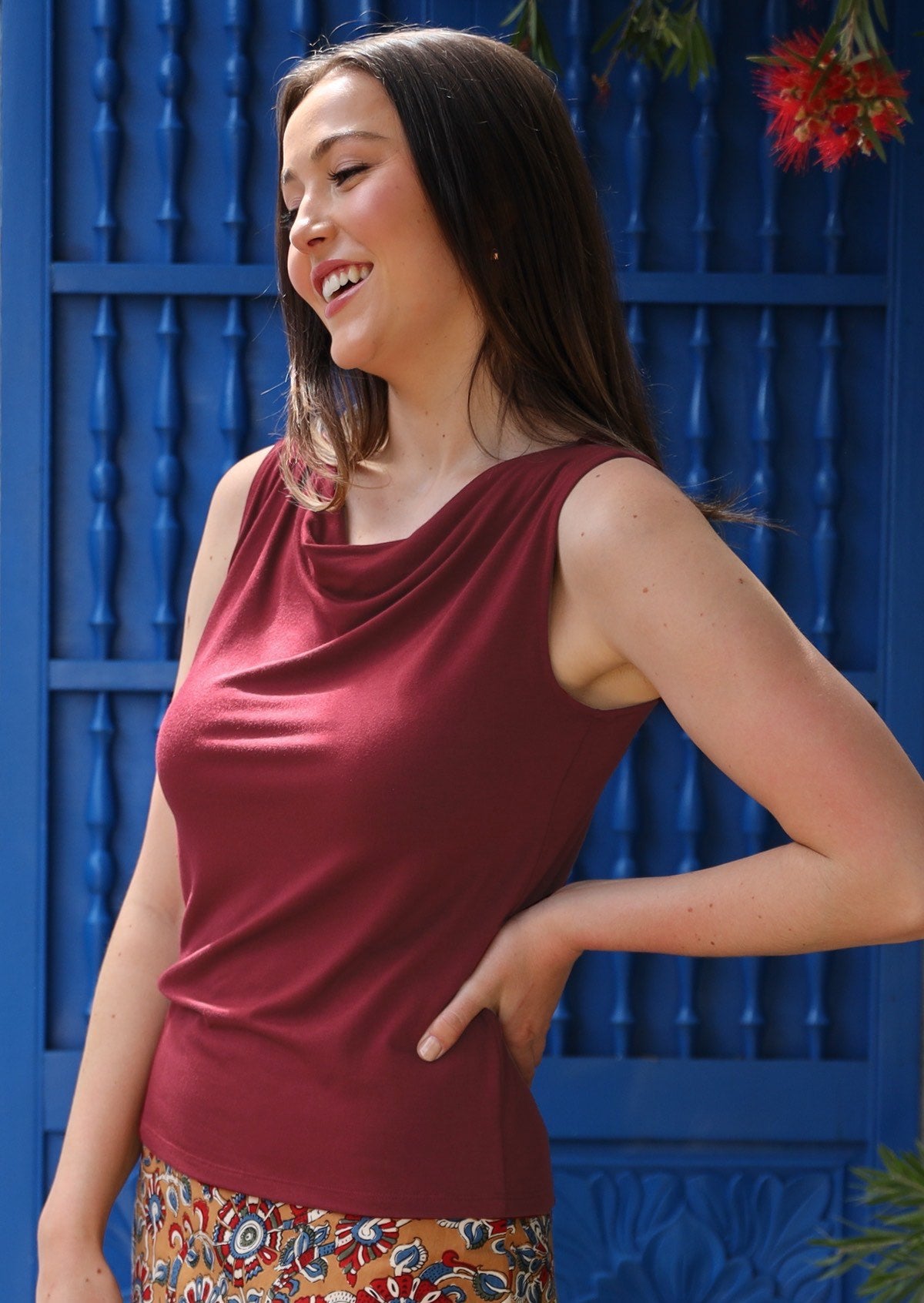 Woman wearing maroon cowl neck singlet top with floral skirt