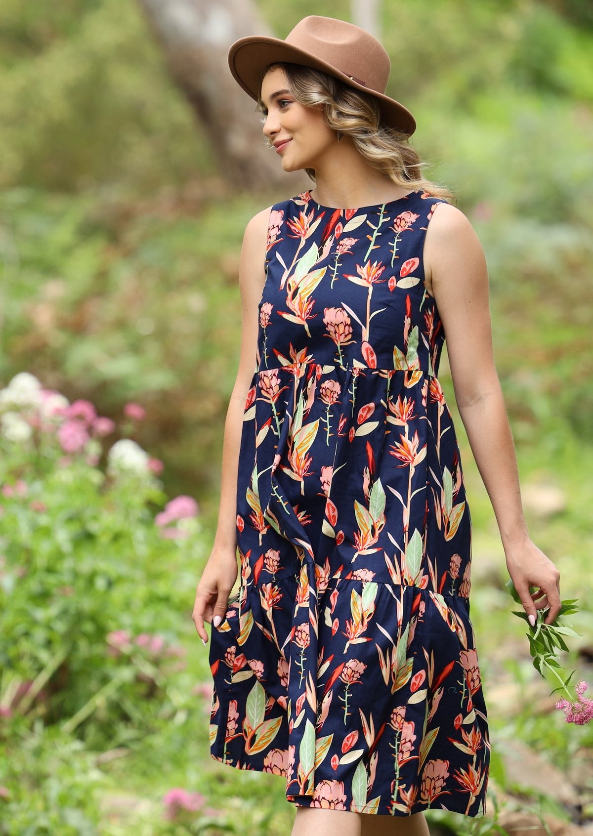 Woman in the forest wearing Floral Printed Cotton Dress navy background pink and green toned native flowers