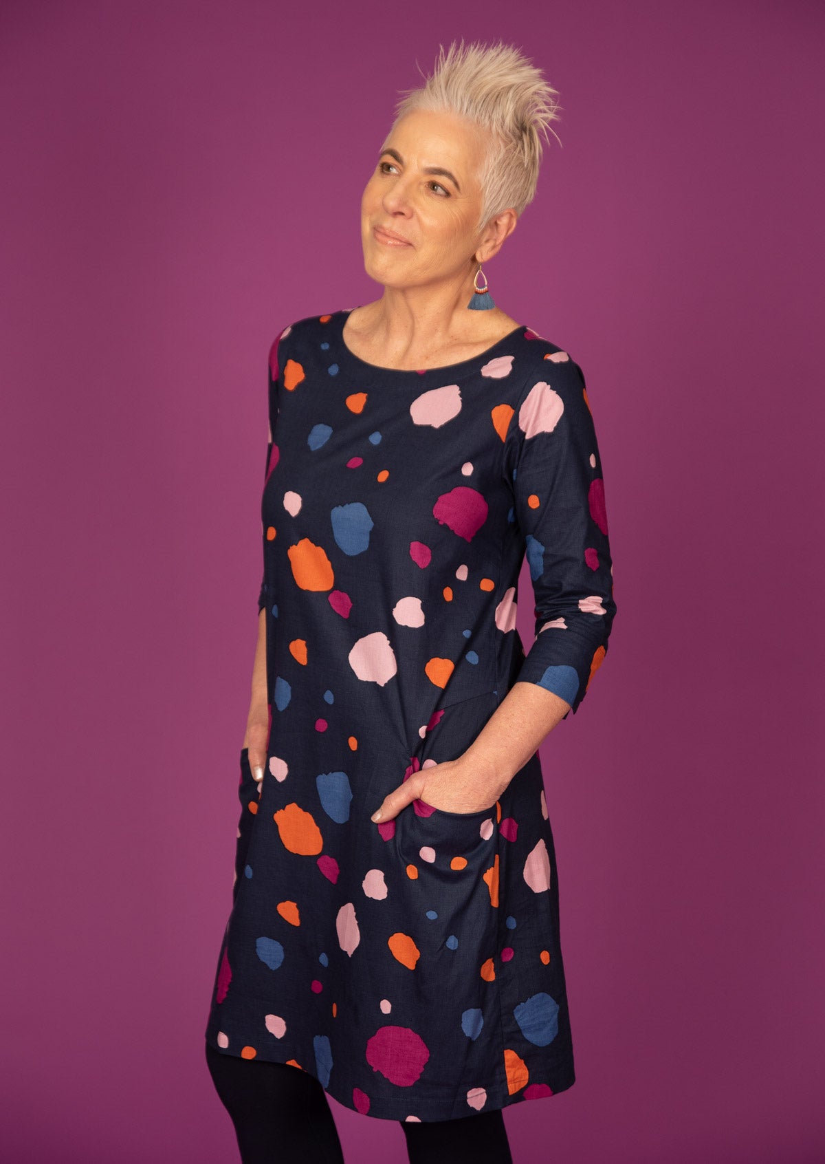 Model wears 3/4 sleeved cotton dress paired with stretchy leggings.