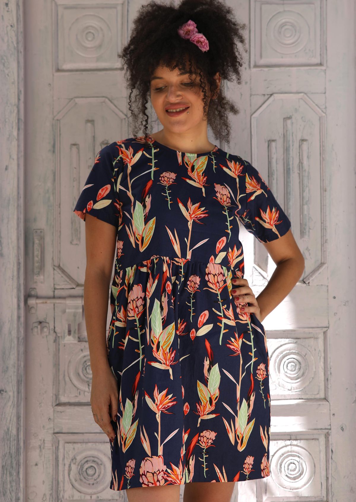 Woman wearing dress with  navy background pink and green toned flowers100% Cotton Designed in Australia