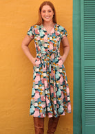 Model wears 100% cotton button through dress with detachable waist tie and hands in pocket.