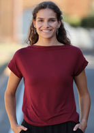 Woman wearing a wide neck mod maroon stretch rayon boat neck top
