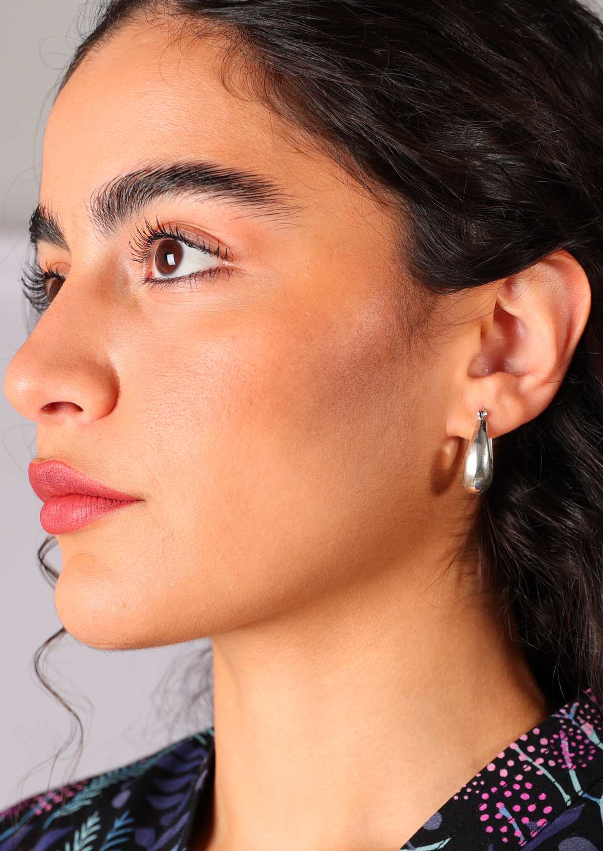 Model wears silver tapered hoop earrings with 9mm width