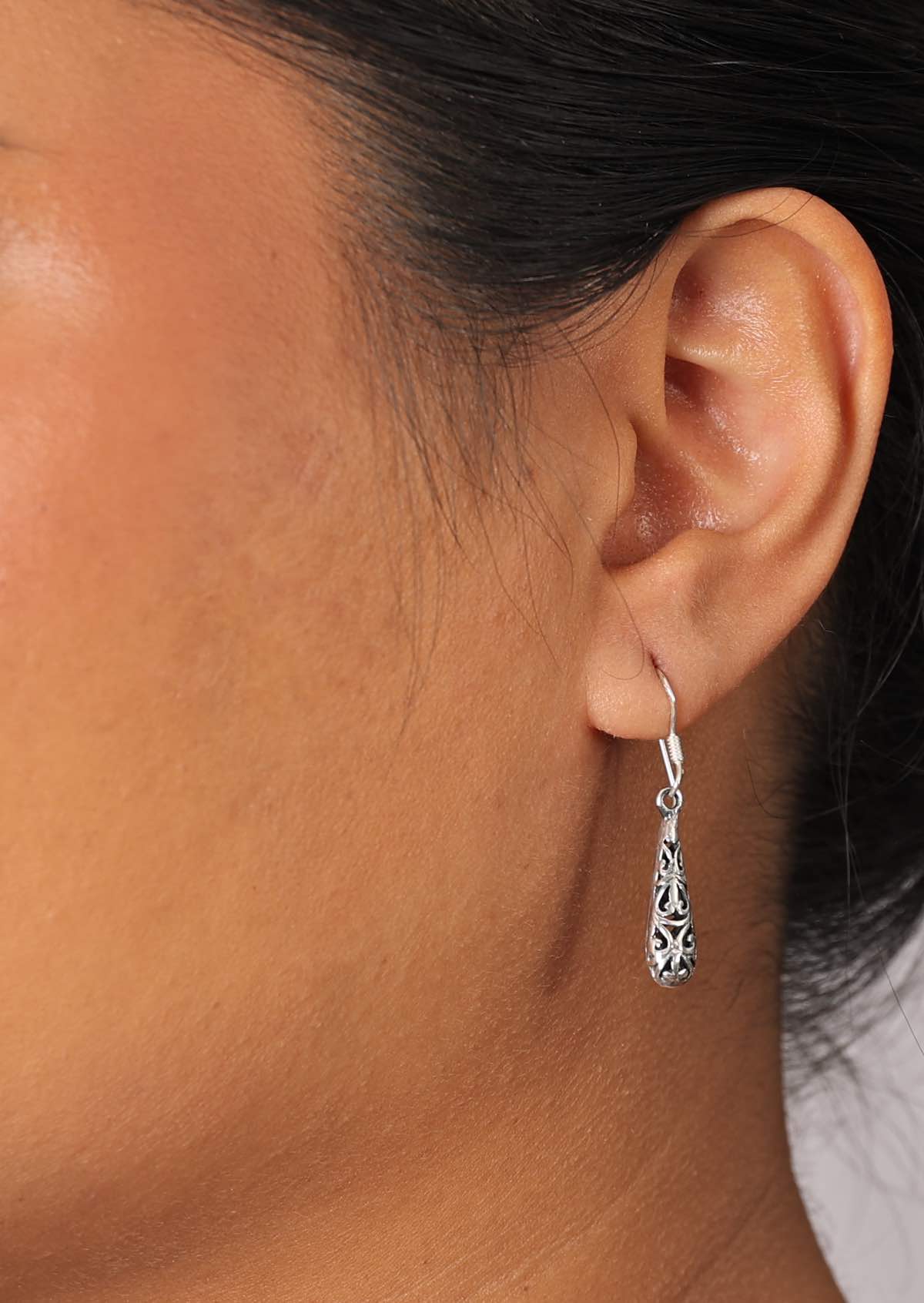 Teardrop shaped sterling silver earrings with ornate detail cutout