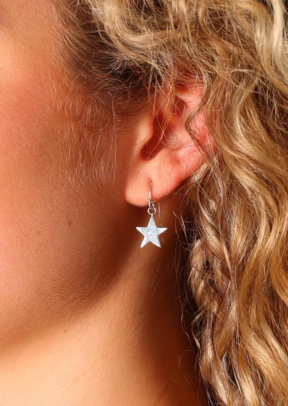 Simple star earrings suspended from wire hook crafted from sterling silver