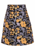 Back view of black based floral print cotton A-line skirt with wide waistband and piped detail