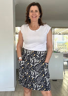 Woman wearing a white t-shirt and 100% cotton skirt with pockets indoors.