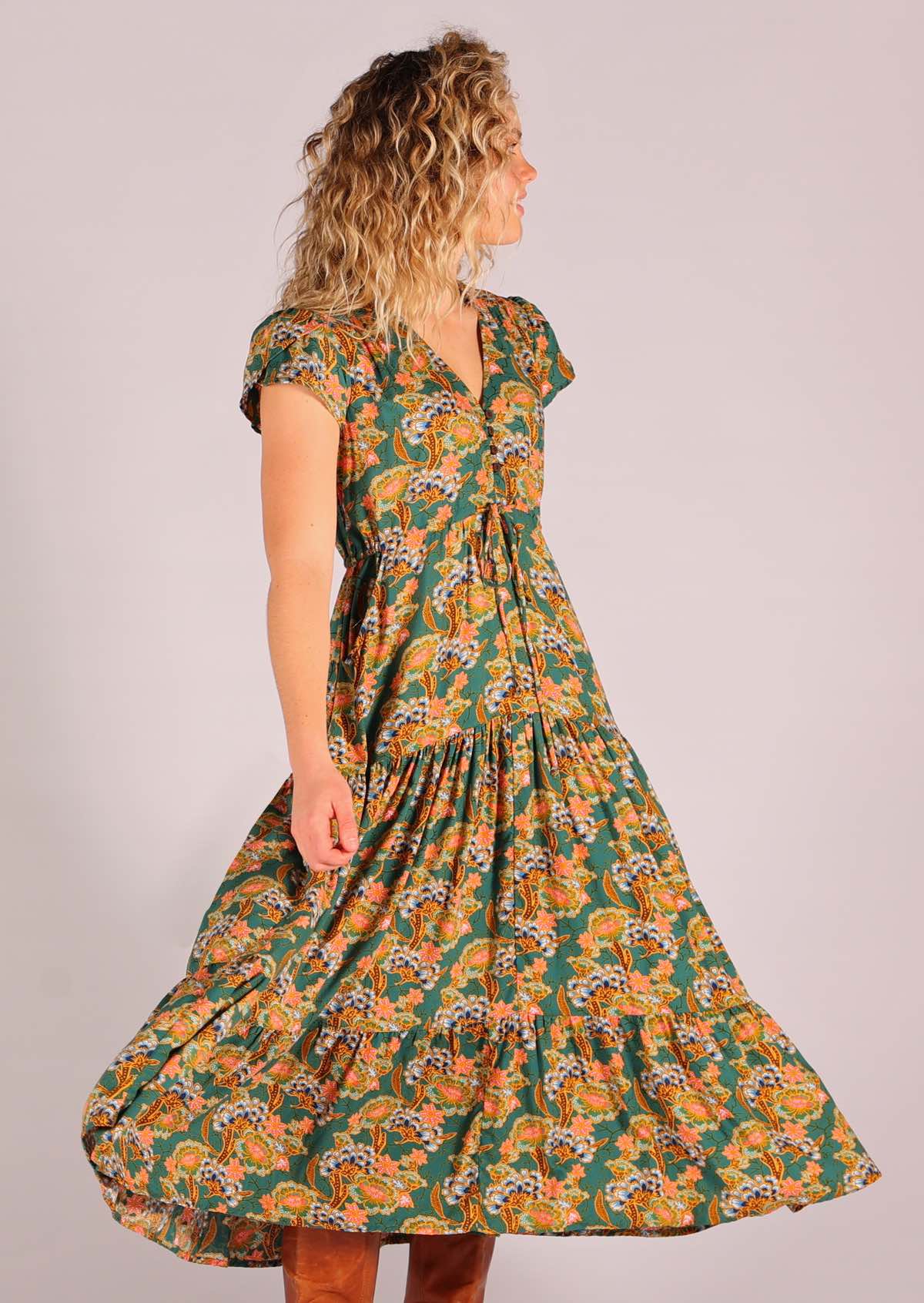 Model twirling wearing green based floral rayon sundress with swishy skirt