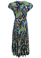 Back view of a rayon maxi dress with generous skirt and cap tulip sleeves in a peacock print