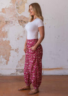 Woman poses in 100% cotton harem pants with wide waistband with elastic at the back and front pockets