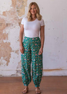 Woman wears cotton harem pants with buttoned ankle and wide waistband