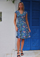 Full length photo of woman in cotton retro inspired dress with cross over bodice, cap sleeves and generous skirt