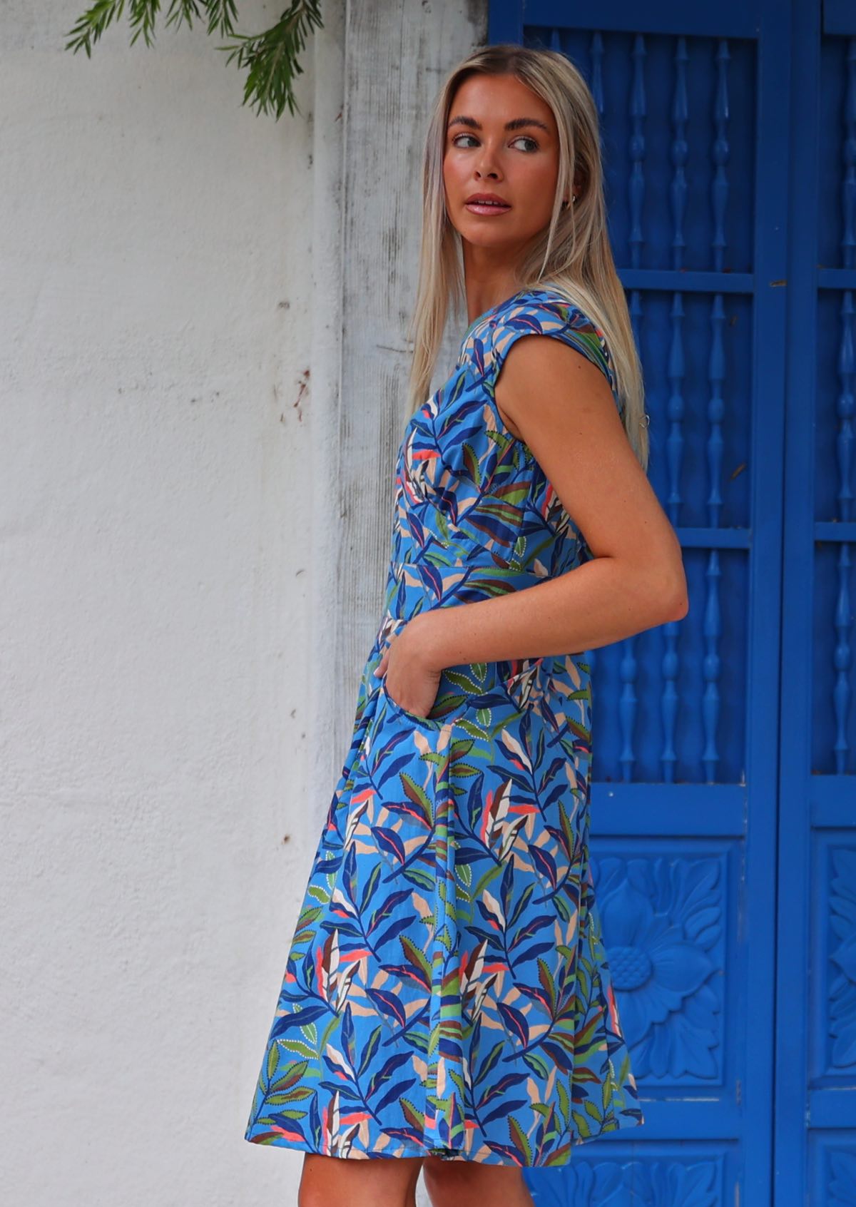 Model wears cotton dress with cap sleeves, generous A-line skirt and pockets