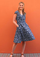 Model standing with hands in pockets wearing 100 percent cotton retro style dress