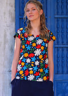 Model poses in fun bold print cotton tailored top with key hole cutout in round neckline