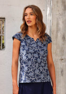 Model wears navy blue cap sleeve  top with a v keyhole neckline made from 100% cotton. 