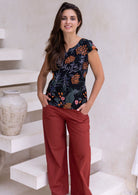 Woman wears 100 percent cotton floral printed tailored top with rust cotton pants
