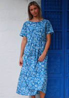 Woman in cotton midi length dress with high round neckline and T-shirt sleeves