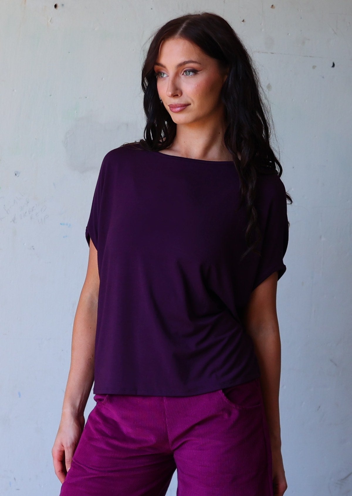 woman with dark hair wearing purple rayon batwing t-shirt
