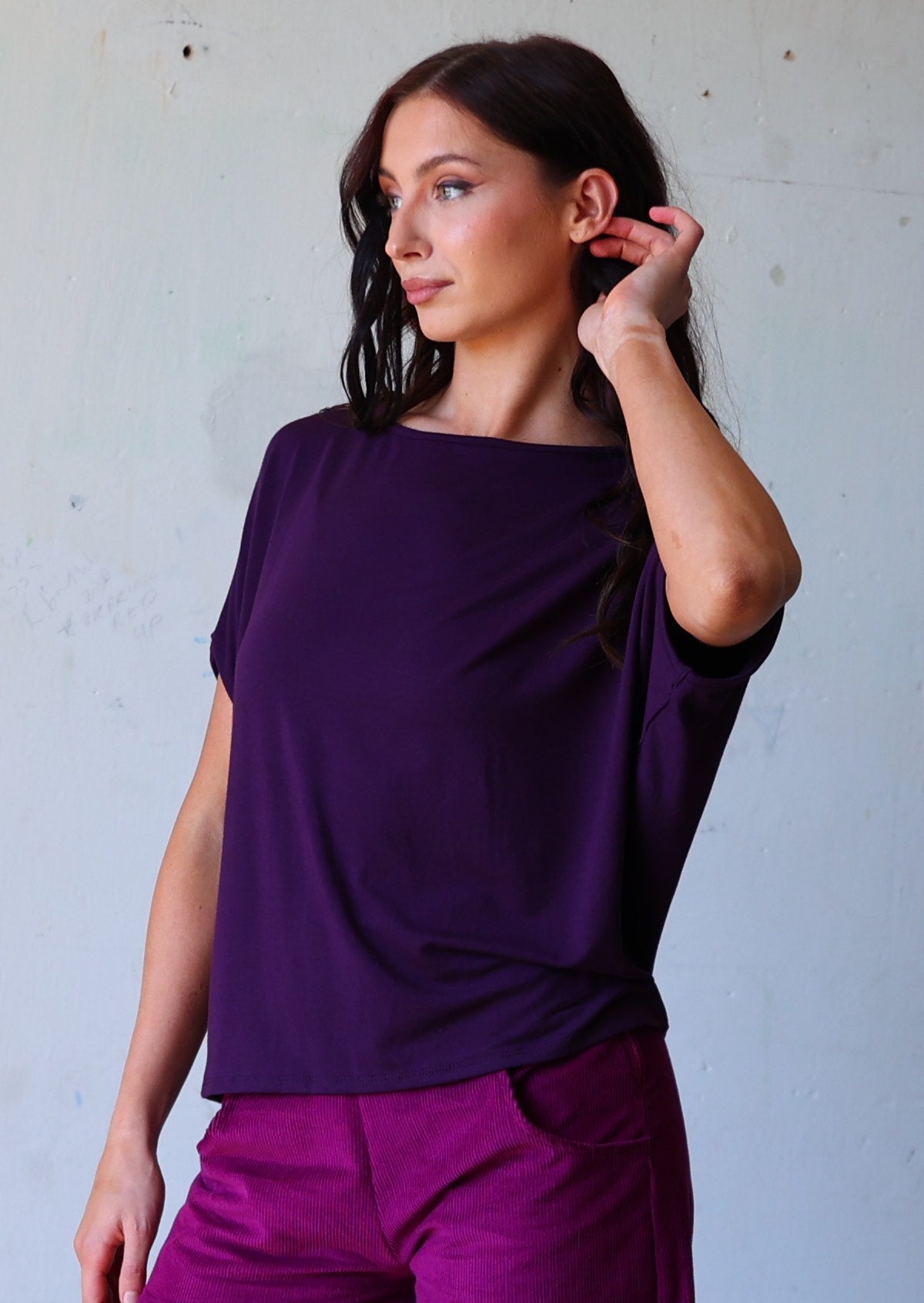 woman with dark hair wearing purple rayon batwing t-shirt