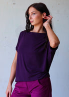 woman with dark hair wearing purple rayon batwing t-shirt